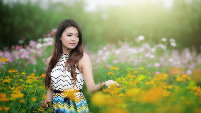 Woman in a patterned dress in a field of yellow flowers