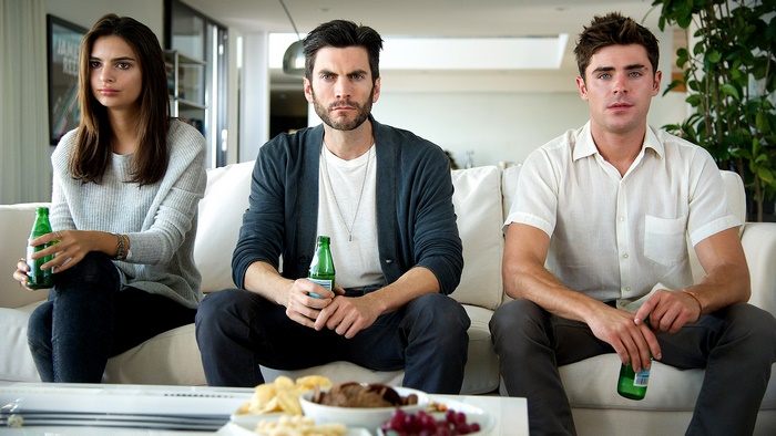 Zac Efron and two others sitting on a couch