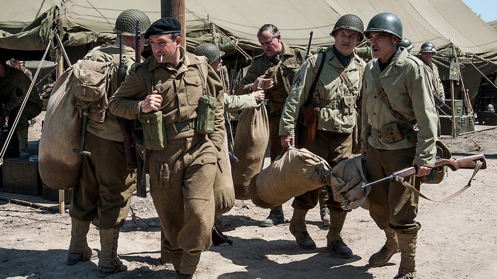 Soldiers carrying bags and rifles