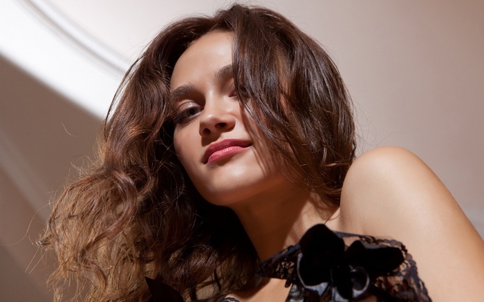 Woman with brown wavy hair wearing black lace