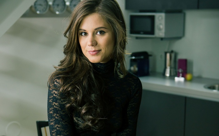 Woman in black lace top in a kitchen