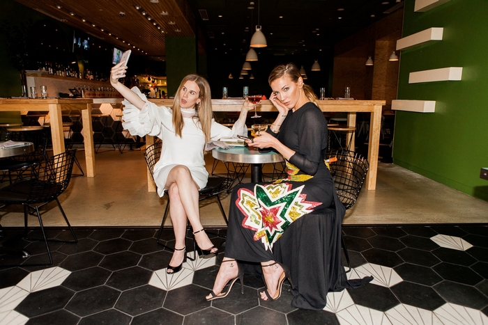 Katie Cassidy takes a selfie with a friend at a restaurant