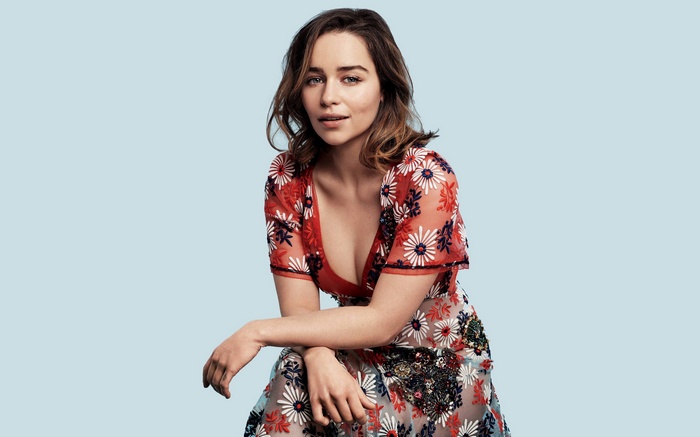 Emilia Clarke posing against a blue background