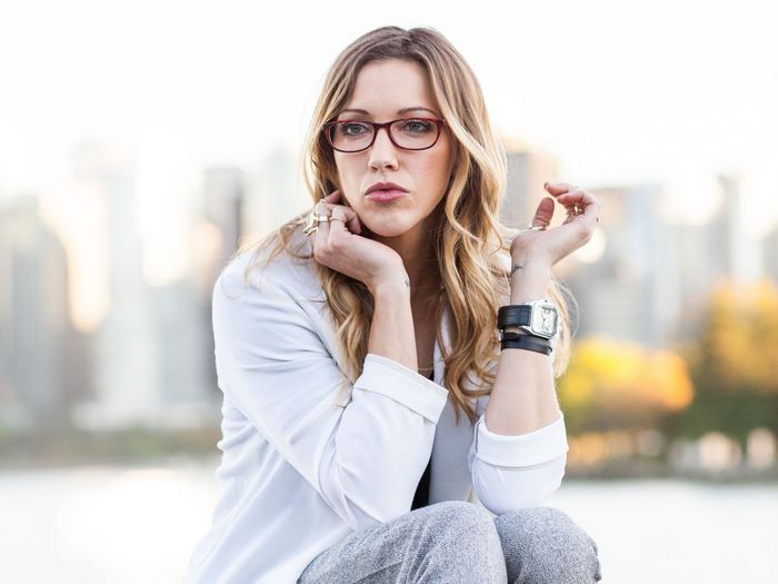 Katie Cassidy wearing glasses and a white blazer