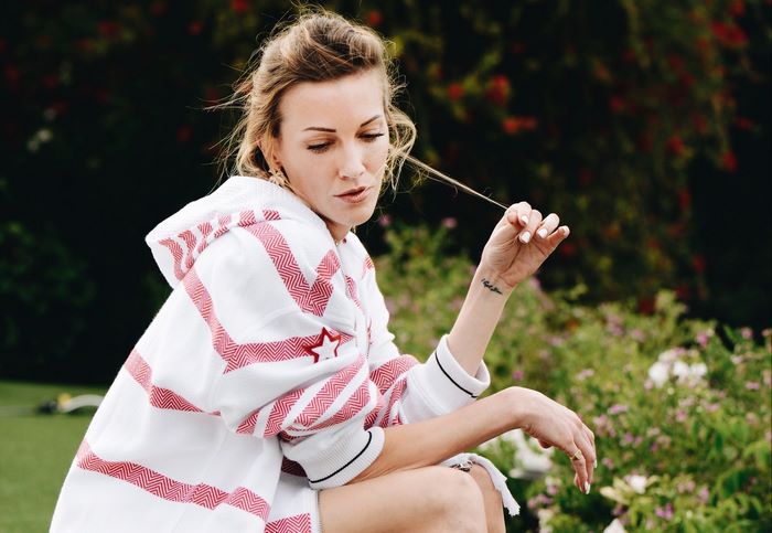 Katie Cassidy in a white and red striped hoodie