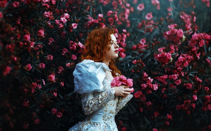 Woman in white dress holding pink flowers