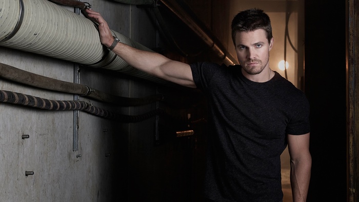 Stephen Amell leaning on pipes