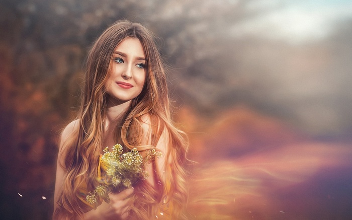 Woman with flowers in a dreamy landscape