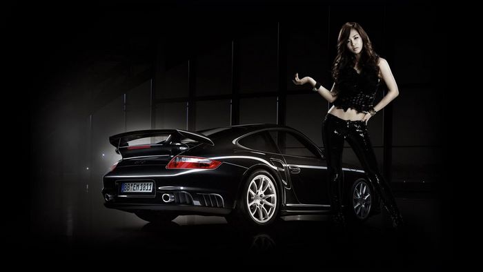 Woman posing with a black Porsche GT2