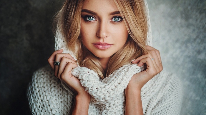 Woman in a white knitted sweater and hood