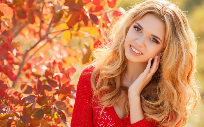 Woman with blonde hair in red sweater outdoors