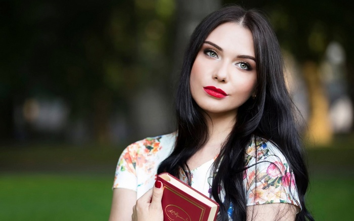 Woman holding a book in a park