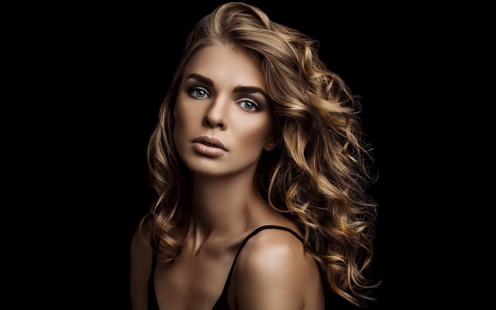 Woman with blonde curly hair and blue eyes
