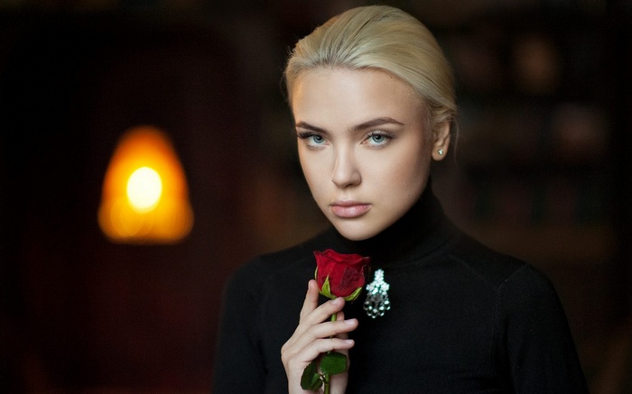 Woman in black turtleneck holding a red rose