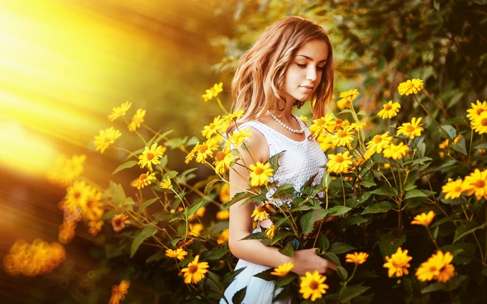 Young woman in white dress among yellow flowers
