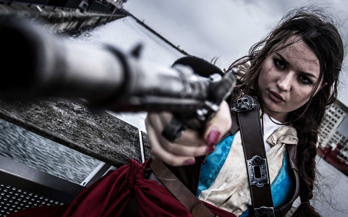 Woman in pirate costume aiming a flintlock pistol