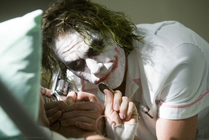 The Joker from The Dark Knight holding a coin