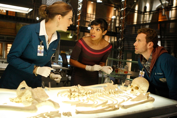 T. J. Thyne and two women examining a skeleton