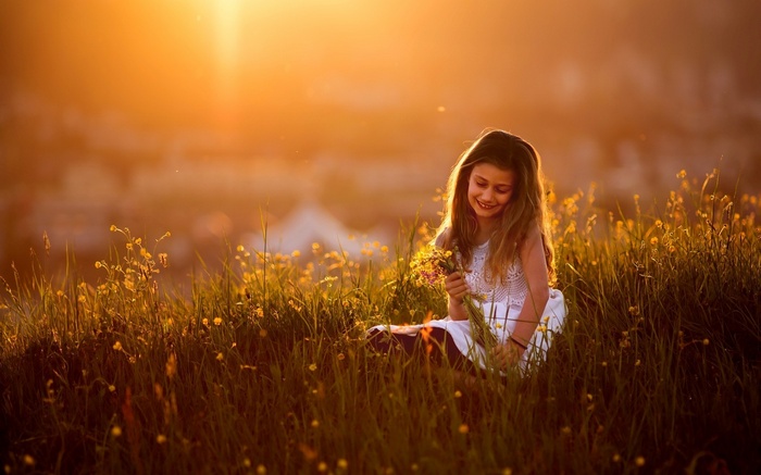 Girl in a field of flowers at sunset
