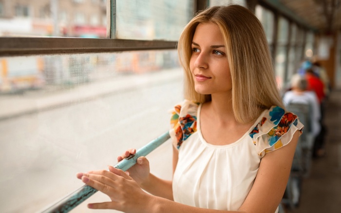 Woman looking out a window on a bus
