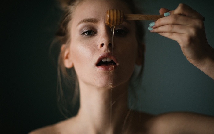 Woman with honey dripping on her face