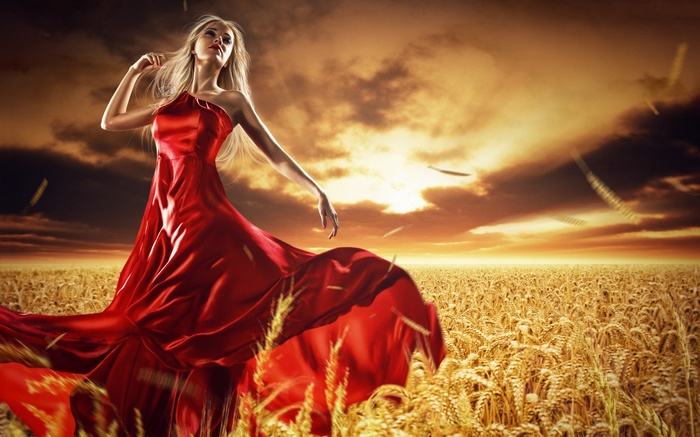 Woman in red dress in wheat field at sunset