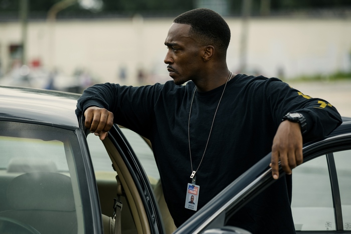 Anthony Mackie leaning on a car