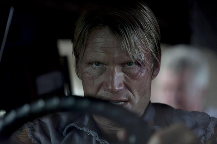 Dolph Lundgren driving a car