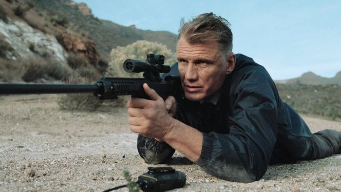 Dolph Lundgren with sniper rifle in desert