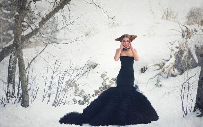 Woman in black dress in snowy forest