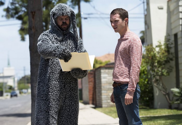 Man in dog costume and Elijah Wood on street