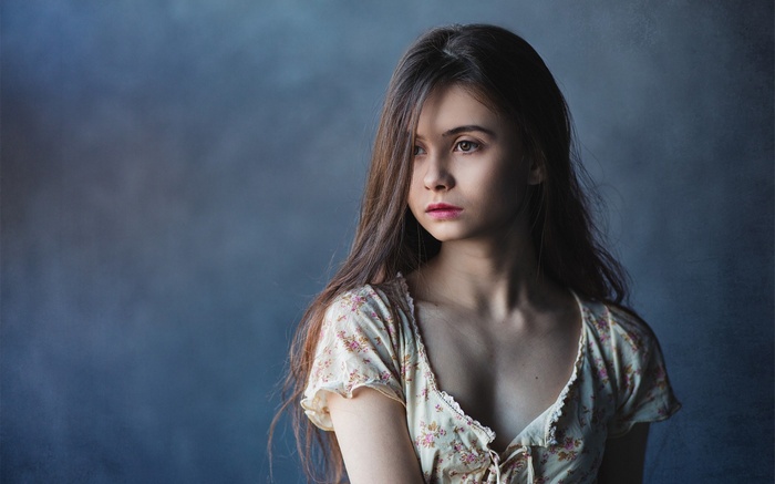 Young woman in floral dress looking away