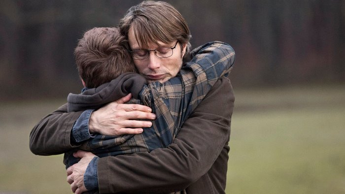 Mads Mikkelsen hugging a child