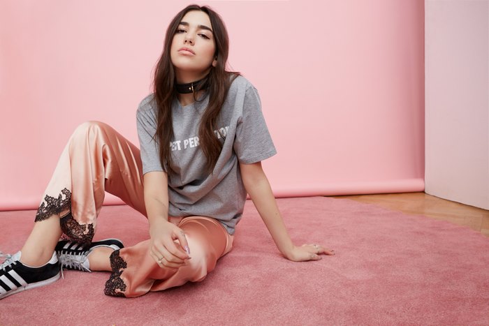 Dua Lipa sitting on pink rug