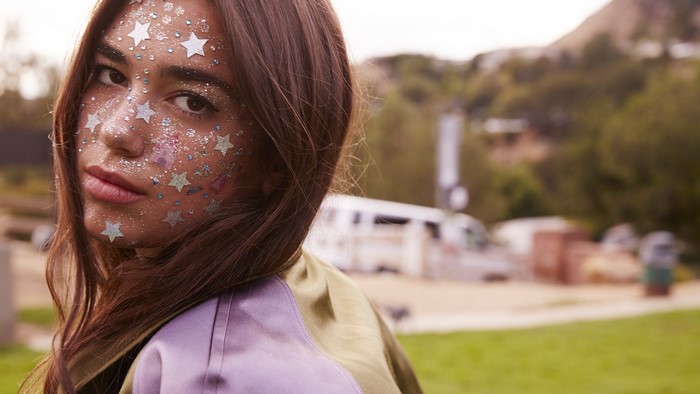 Dua Lipa with glitter and stars on her face