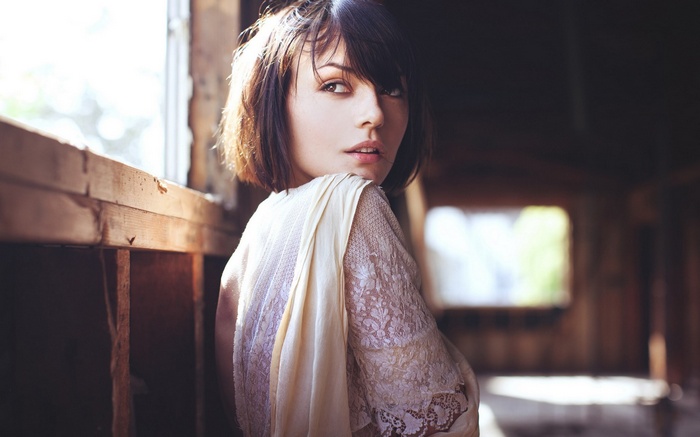 Woman in lace dress by window