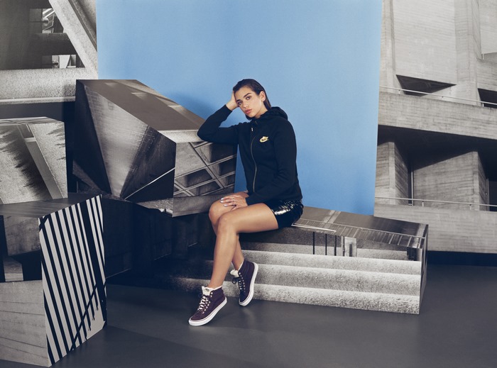 Dua Lipa sitting on a bench