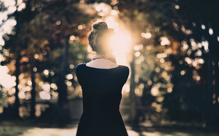 Woman with hands on neck in sunlight