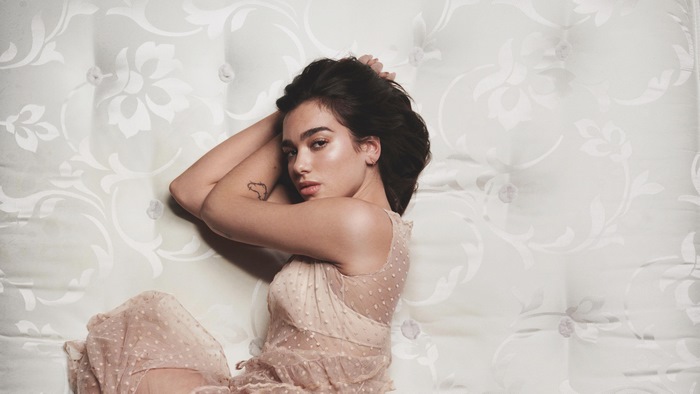 Dua Lipa lying on a patterned mattress