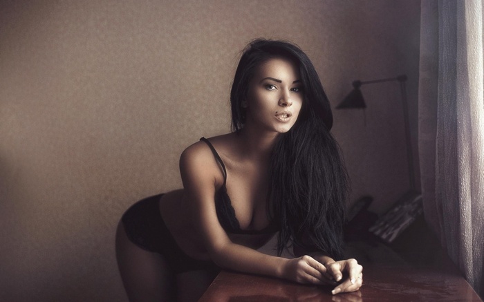 Woman in lingerie leaning on a table