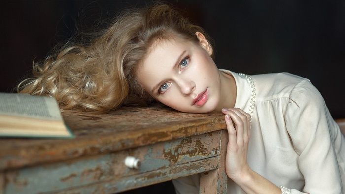 Young woman resting head on a wooden table
