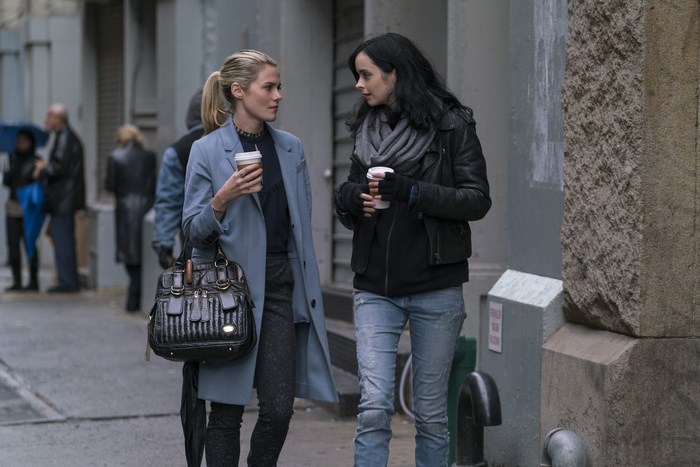 Jessica Jones and friend walking with coffee