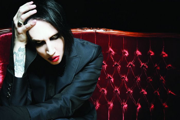 Marilyn Manson on a red couch