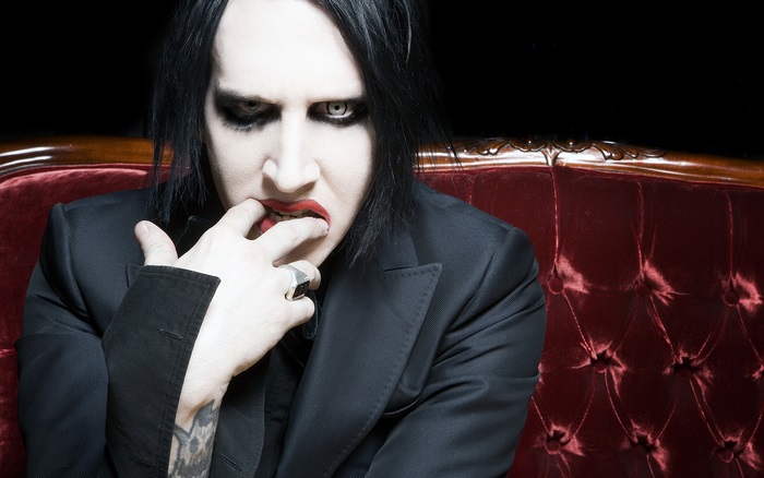Marilyn Manson on a red couch
