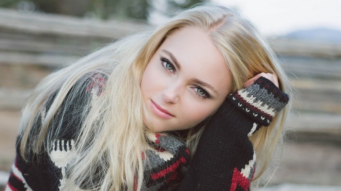 Young woman with blonde hair wearing a sweater