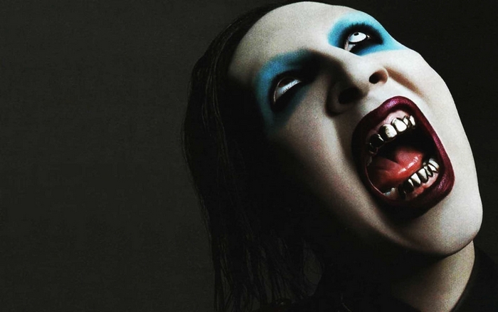 Marilyn Manson with blue eye makeup and gold teeth