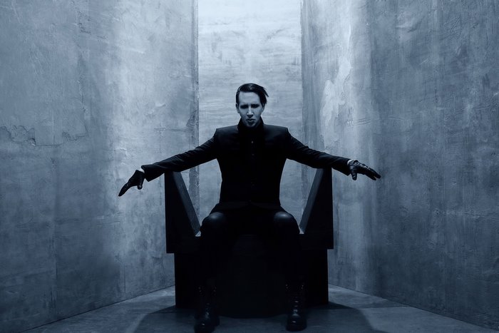 Marilyn Manson sitting on a throne