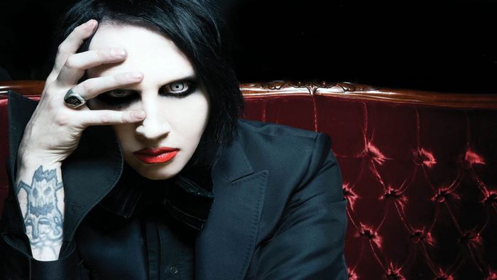 Marilyn Manson on a red couch