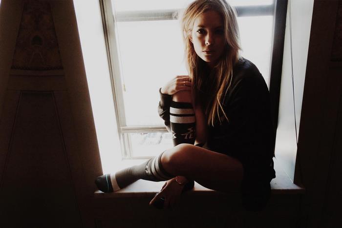 Ashley Benson sitting by a window