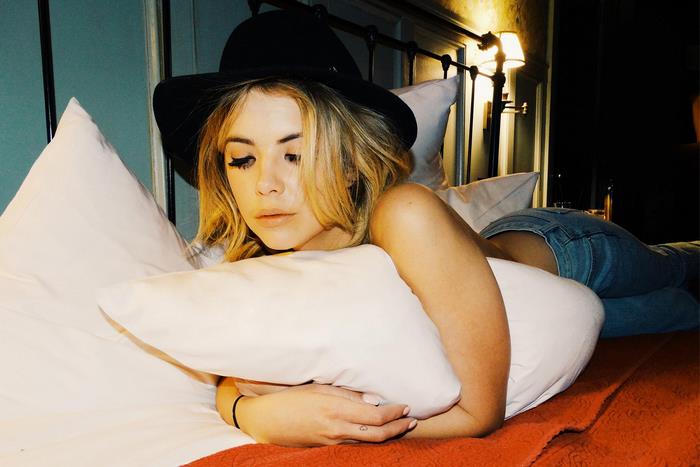 Ashley Benson lying on a bed